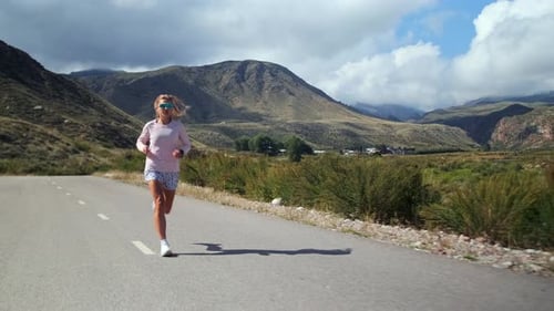Athlete Runs on a Mountain Road Picking Up the Pace Improving Endurance