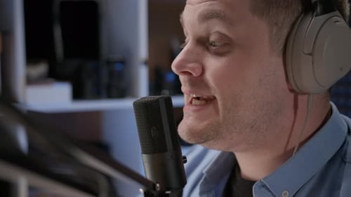Close Up Radio Host Sit in Studio and Communicates with Audience Man in Blue Shirt and Headphones