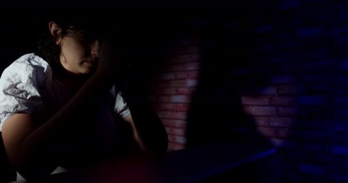 Woman in Prayer with Rosary and Brick Wall