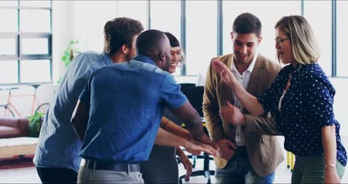 Happy Team Stacking Hands in Modern Office
