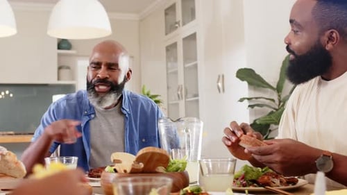 Friends Eating and Talking Together at Kitchen Table