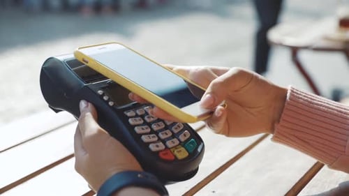 Customer Paying for Order in the Cafe with Payment Terminal Using NFC Smartphone Technology Closeup