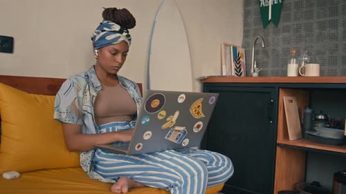 Woman Using Laptop at Home on Couch