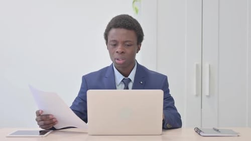 Focused Professional in Modern Office Working on Laptop