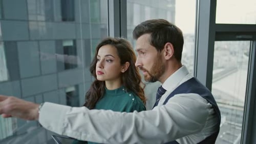 Business Colleagues Discussing Project near Office Window