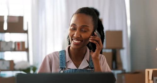 Woman Talks on Phone While Working At Desk