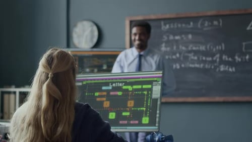 Programming Teacher Speaking to School Girl during Lesson