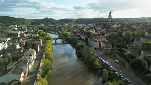 A tranquil river in Périgueux, France, flows gently with the city's cathedral prominently visible in