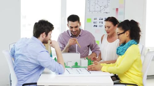 Startup, Architektur, Teamwork und Bürokonzept - Lächelnde Architekten mit Hausmodell und blauem...