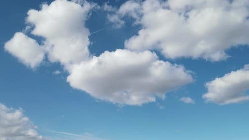 Fluffy White Clouds Float in the Blue Sky