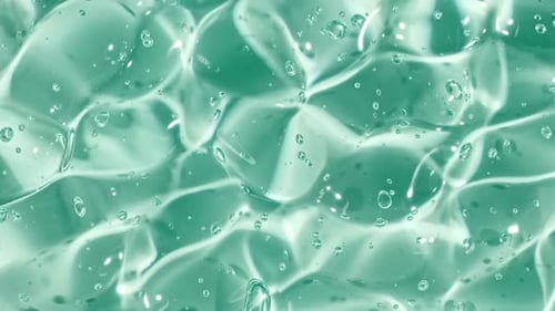 Gel cosmétique fluide bleu transparent avec des bulles de molécules coulant sur la surface blanche unie