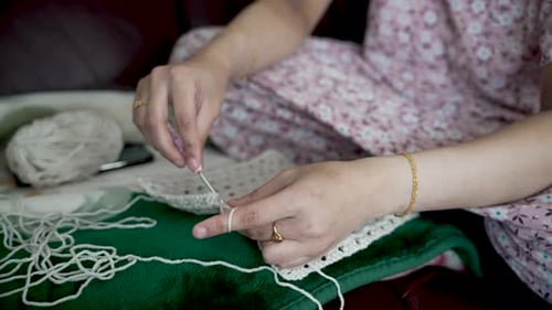 Woman Crocheting with White Yarn Inside Home