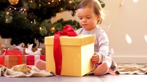 Adorable Infant Opening a Christmas Gift