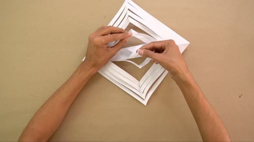Crafting Intricate Paper Snowflake Decoration by Hand