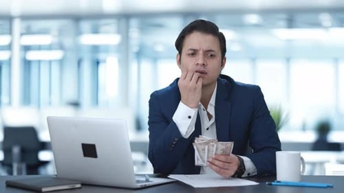 Confused Indian businessman counting money