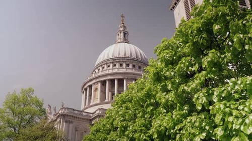 Beautiful view of famous St. Paul church's dome with trees in the foreground during daytime as the w