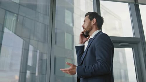 Serious Boss Talking Mobile Phone At Office Wearing Stylish Suit Close Up. Stressed Businessman H...