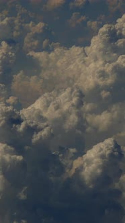 Prenez des photos de la forme et des formations des nuages depuis le hublot de l'avion avec un éclairage Théâtral