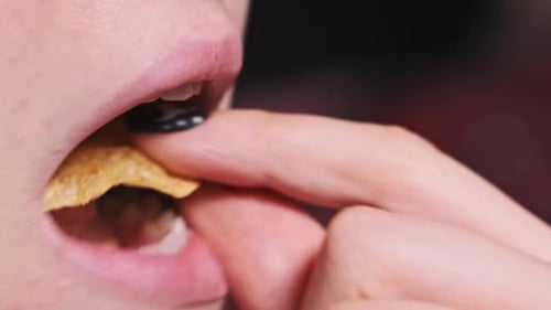 Close Up of Person Eating Potato Chip