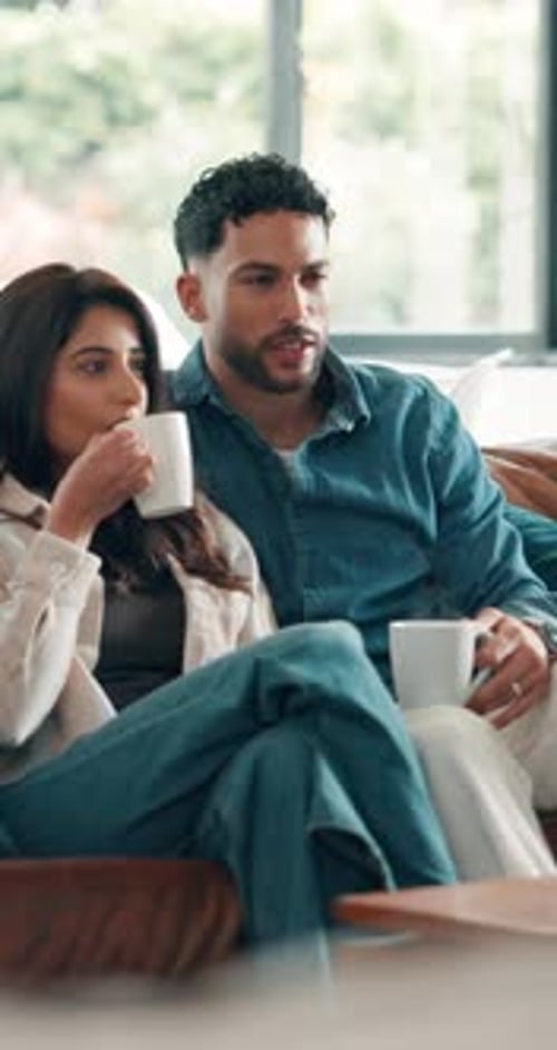 Couple Relaxing and Drinking Coffee on the Sofa
