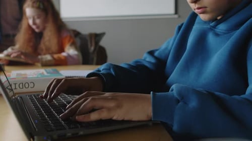 Geeky Teenage Indian Boy Writing Code on Laptop at IT Class