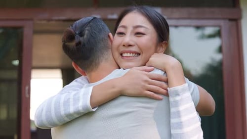 Woman Smiles While Hugging Man from Behind