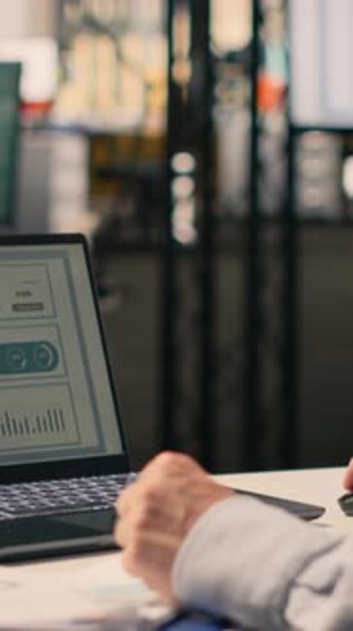 Vertical Video Professional Worker Reviewing Compliance Data on Laptop Screen at Desk