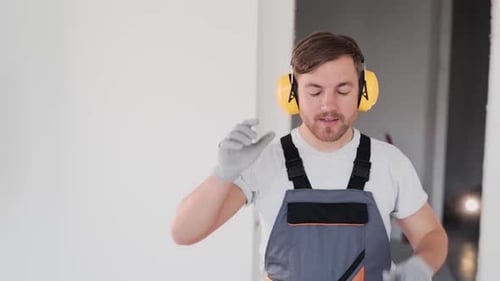 Smiling Man Holds Power Drill Indoors