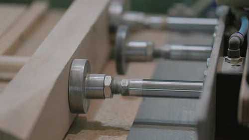 A man works with wood in a workshop. Working with wooden blanks. A man drills holes in wooden blanks