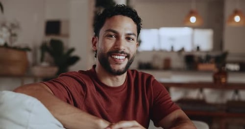 Man Smiling while Sitting on a Couch