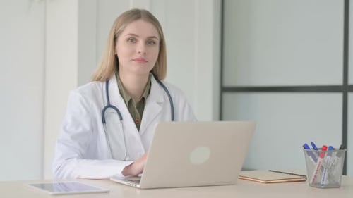 Lady Doctor Smiling at Camera at Work in Clinic