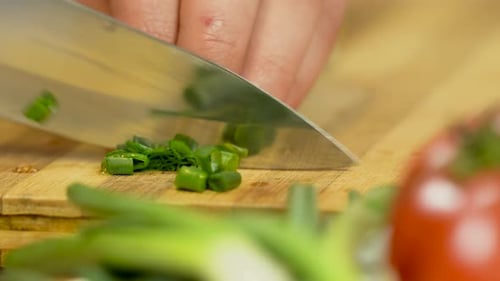 Chopping green onion. Chef cutting fresh, green onion with sharp knife.