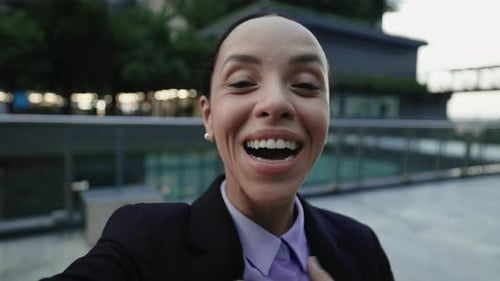 Smiling Woman in Suit Talking to Camera Outdoors