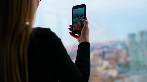Adult Woman Records Cityscape with Mobile Phone