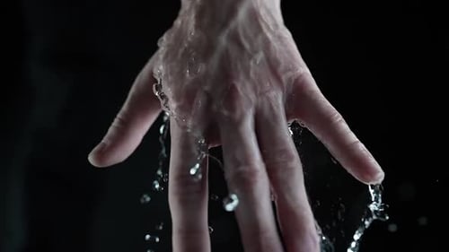 Hand in Water Splash with Dark Background Closeup