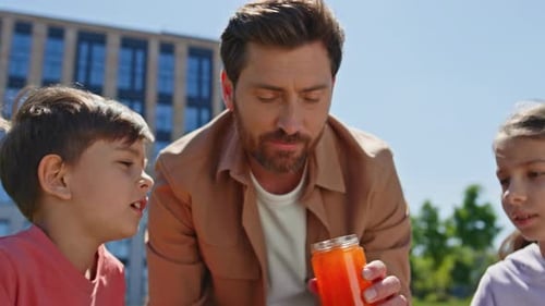Father and Children Enjoying Picnic in Park