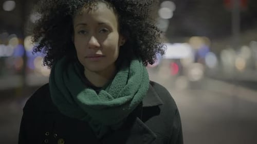 Mulher atenciosa com cabelo encaracolado Braun viajando pela cidade à noite