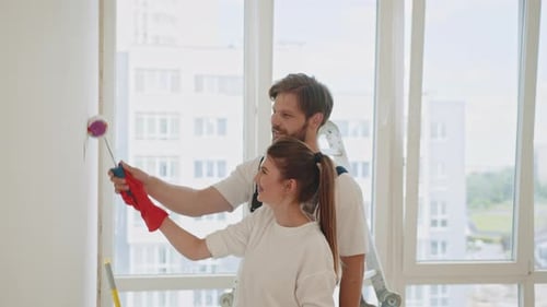 Couple Painting Wall Together in New Apartment