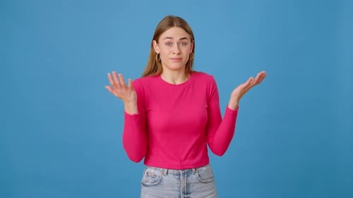 Confused Lady Spreading Hands in Bewilderment in Blue Studio