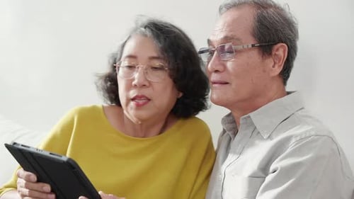 Senior Couple Using Tablet at Home Together
