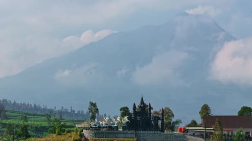 Le château touristique de Negeri Kahyangan et les montagnes environnantes en arrière-plan.