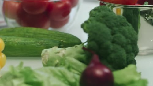 Fresh Pepper Lying On Cutting Board. Closeup Pepper, Lettuce And Cucumbers On Kitchen Table. Macr...