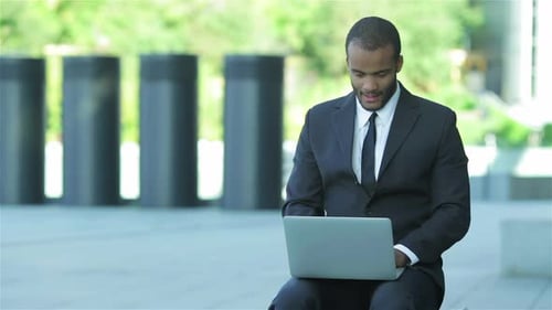 Young Man Working on Laptop Outdoors