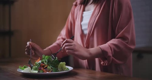 Young Adult Mixing Salad Indoors