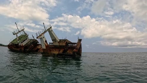 POV von einem Boot, das auf ein altes, rostiges Boot zusteuert, das vor São Tomé gestrandet ist.Afrika