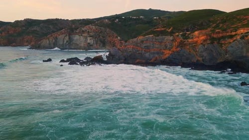 Golden Hour Sunset Over Dramatic Coastal Cliffs and Rolling Waves