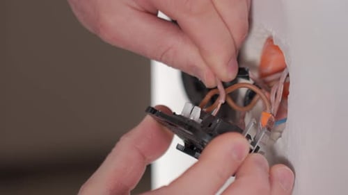 Man's Hands Wiring An Electrical Outlet in Home