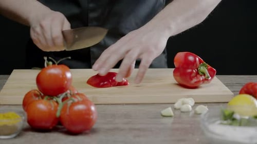 El cocinero corta los pimientos en la cocina del restaurante