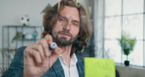 Close up of businessman office worker which writing notes on glass board in modern office room