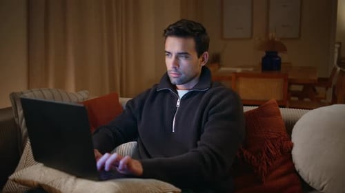 Young Adult Working on Laptop at Home at Night